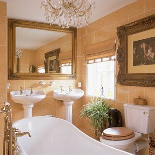 golden bathroom with twin basins and mirror