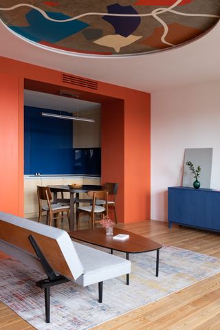 A living room with red walls, and blue backsplash