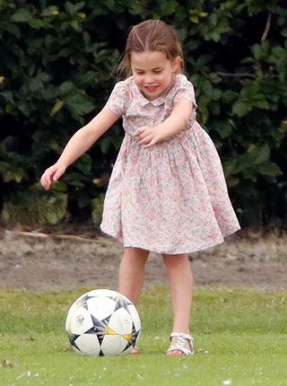 Princess Charlotte playing football wearing a smocked dress