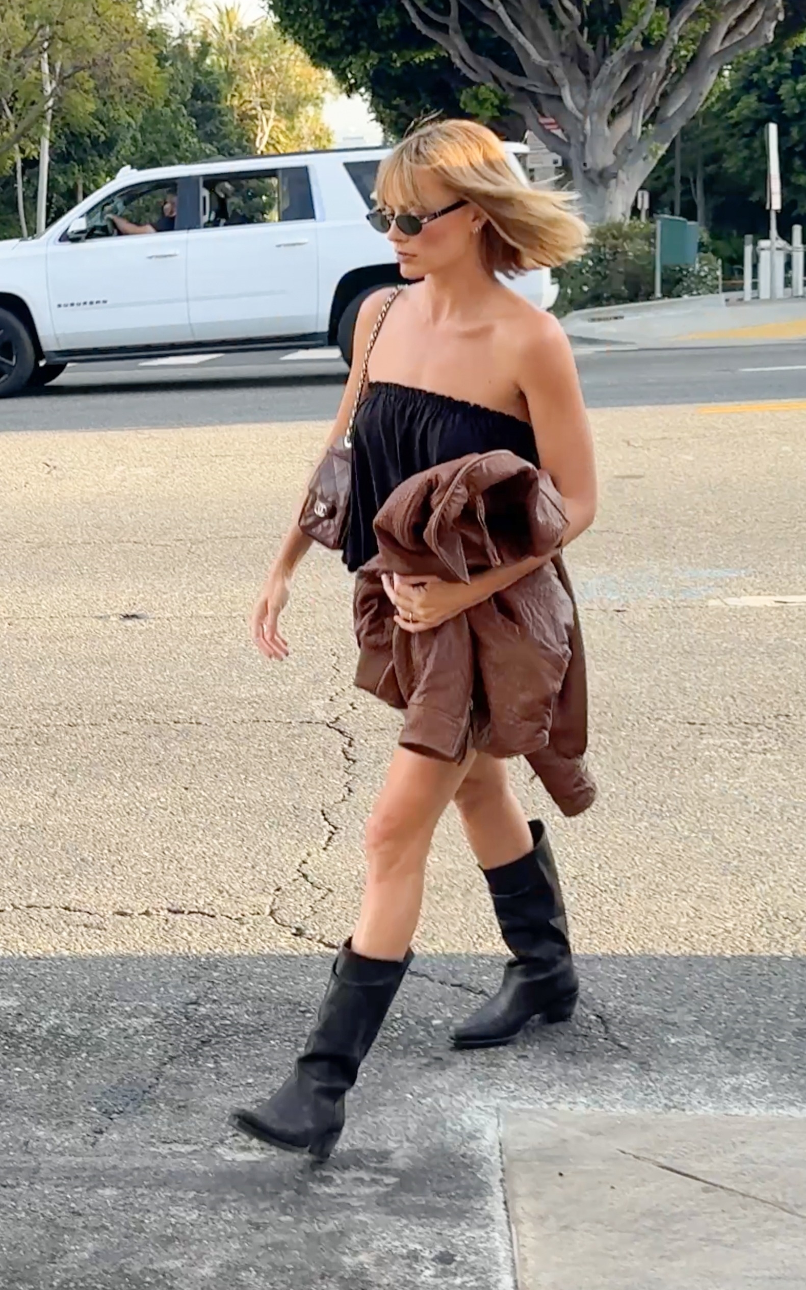 Margot Robbie carries a chestnut leather jacket and a dark burgundy Chanel 25 mini bag