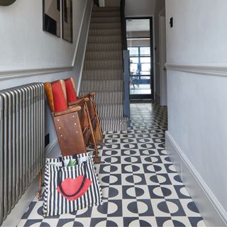 A hallway with a staircase and a patterned flooring