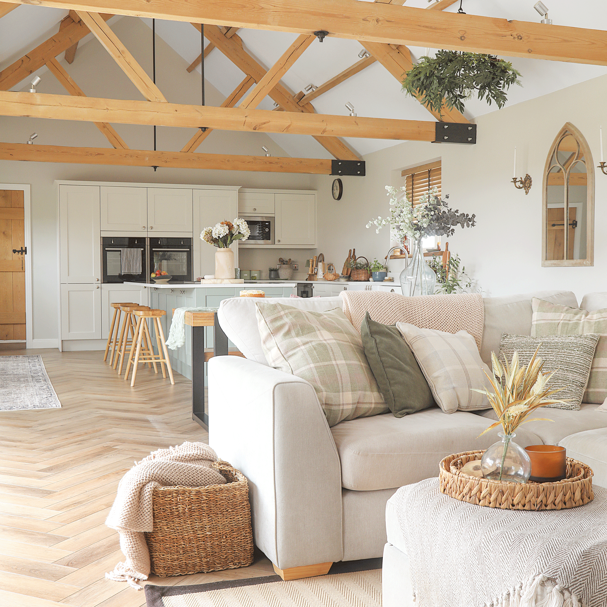 an open plan kitchen dining living space with vaulted ceilings and herringbone flooring