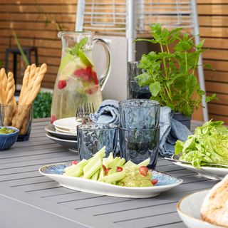 Outdoor table with plates, glasses and water jug