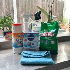 Washing machine cleaning products and a cloth sitting on a kitchen counter