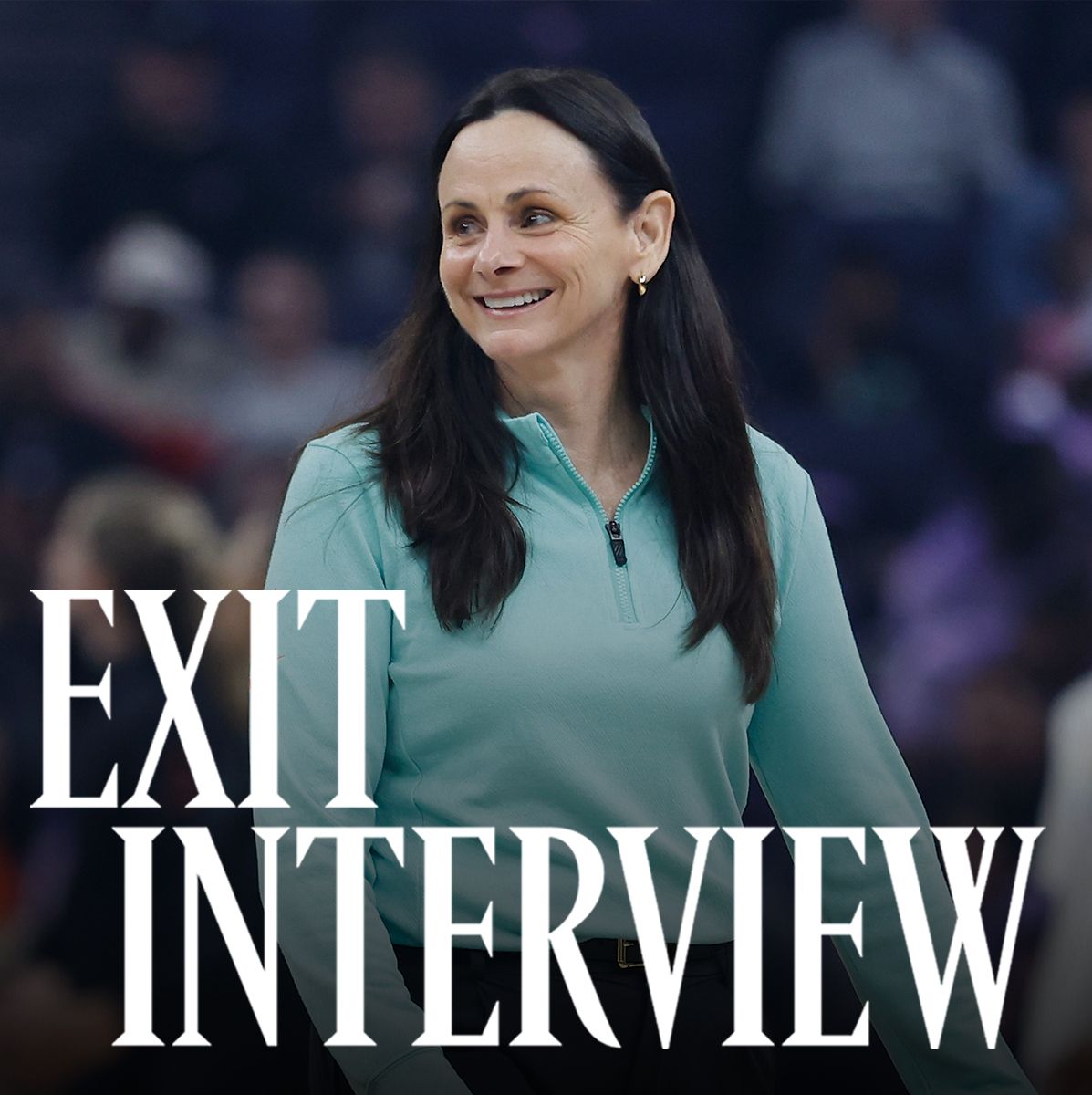 Sandy Brondello, smiling courtside in a teal zip-up top, during a WNBA game. The words “Exit Interview” appear in bold white text across the lower part of the image.