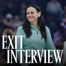 Sandy Brondello, smiling courtside in a teal zip-up top, during a WNBA game. The words “Exit Interview” appear in bold white text across the lower part of the image.