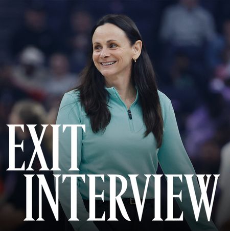Sandy Brondello, smiling courtside in a teal zip-up top, during a WNBA game. The words &ldquo;Exit Interview&rdquo; appear in bold white text across the lower part of the image.