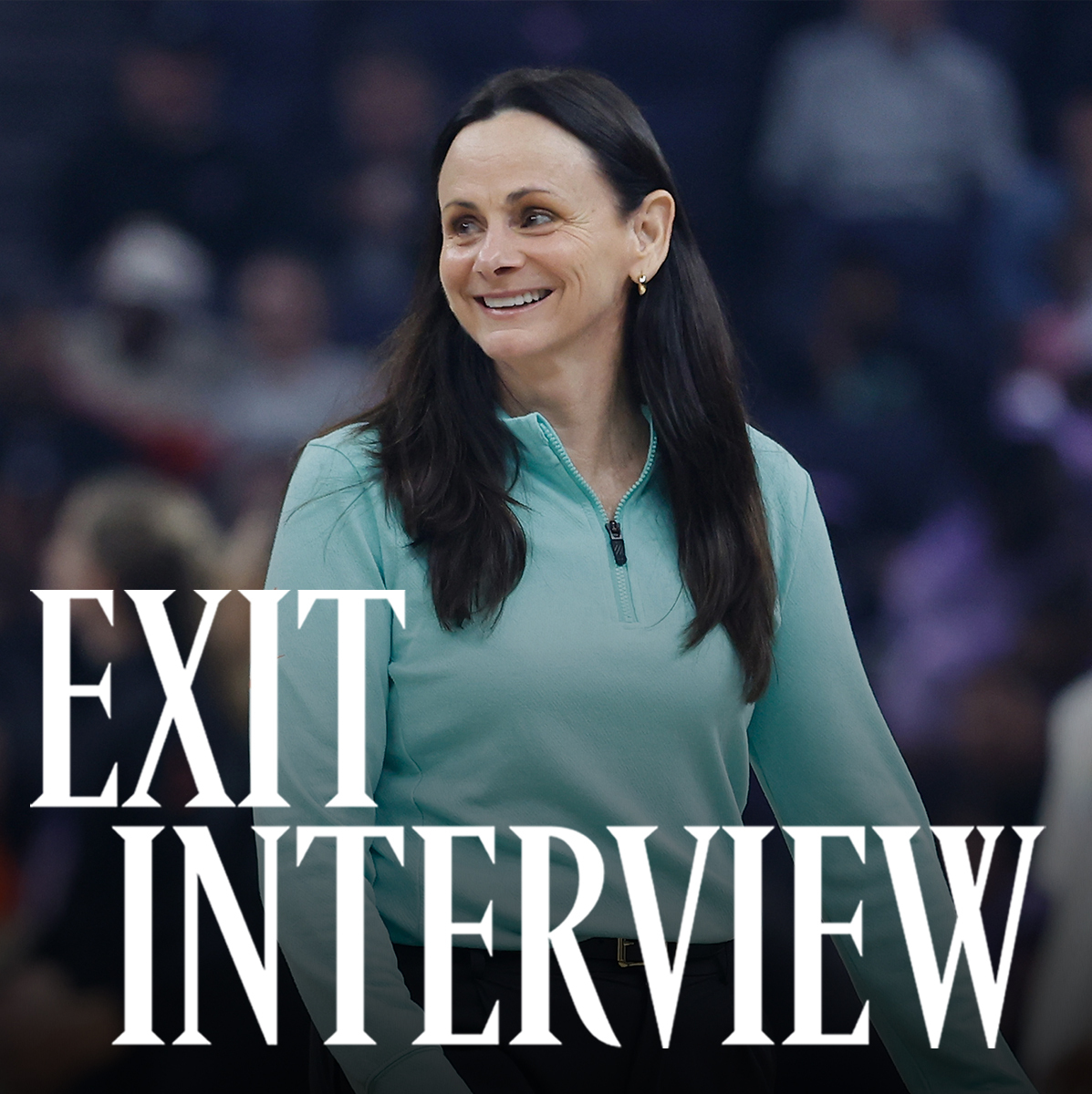 Sandy Brondello, smiling courtside in a teal zip-up top, during a WNBA game. The words \201cExit Interview\201d appear in bold white text across the lower part of the image.