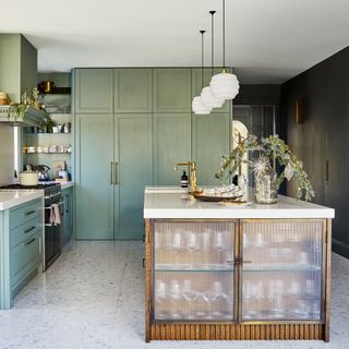 kitchen area with teal colour kitchen units and white marble countertop and white ceiling lamps