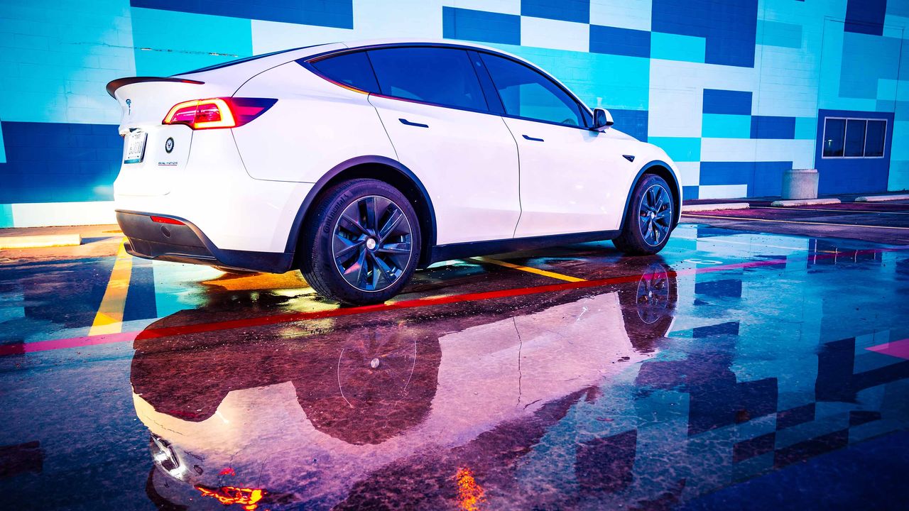 Tesla sedan in front of a bright-colored background