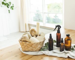 Straw basket with ECO-friendly hygienic supplies and organic cleaning items, wooden reusable brushes of coconut bristles.