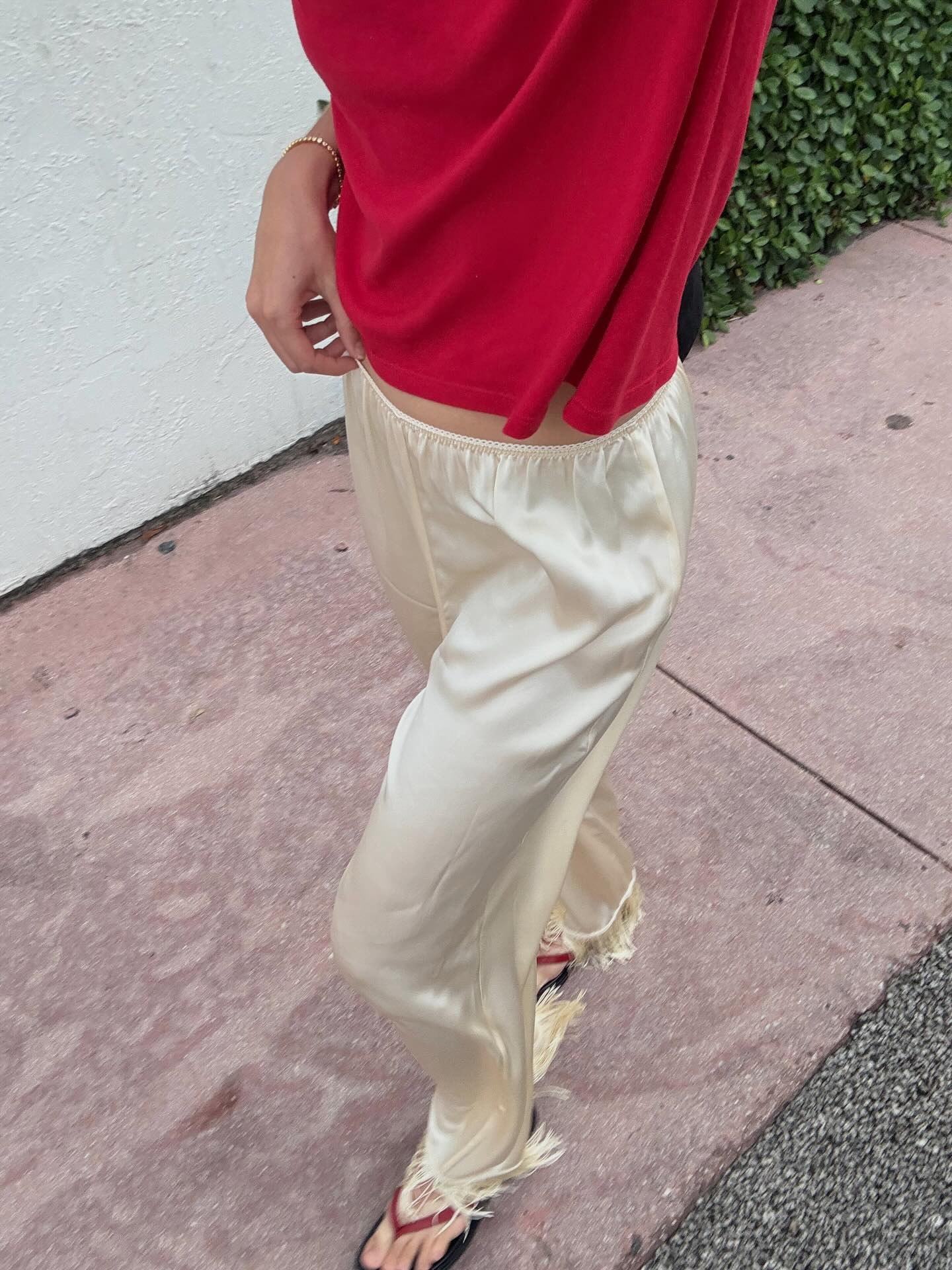 Woman in a red tee and silk fringe pants