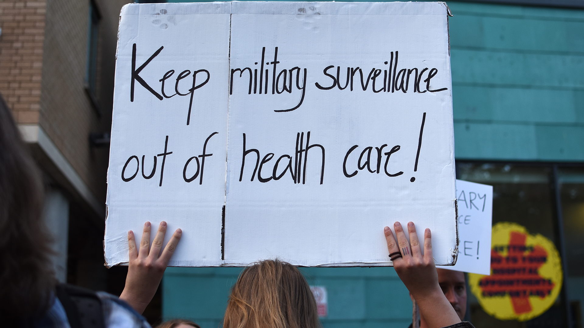 Woman holding placards against Palantir in the NHS in front of the Bristol Royal Infirmary during a protest on October 1, 2026