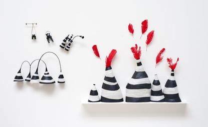 Soft striped vases decorated with red feathers and floating binoculars