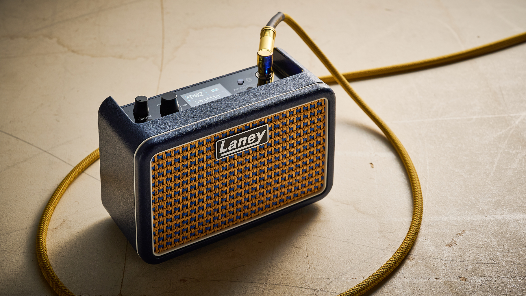 A Laney Prism Mini guitar amp with a guitar cable plugged into it