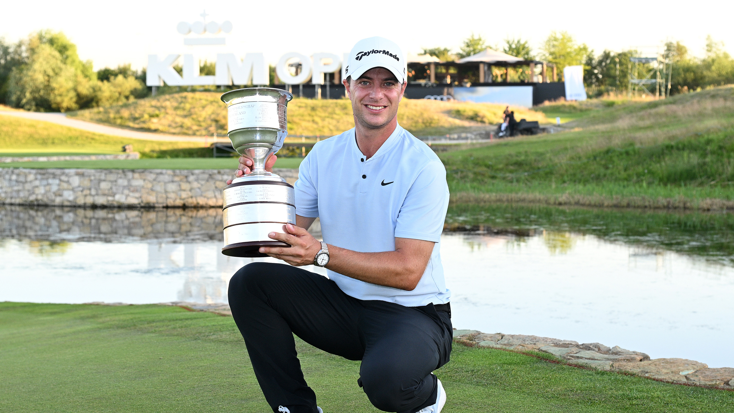 Guido Migliozzi holds the KLM Open trophy on a putting green