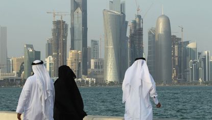 Men look at the Qatar skyline