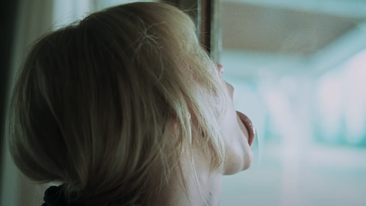 Grace licking a window in Die, My Love
