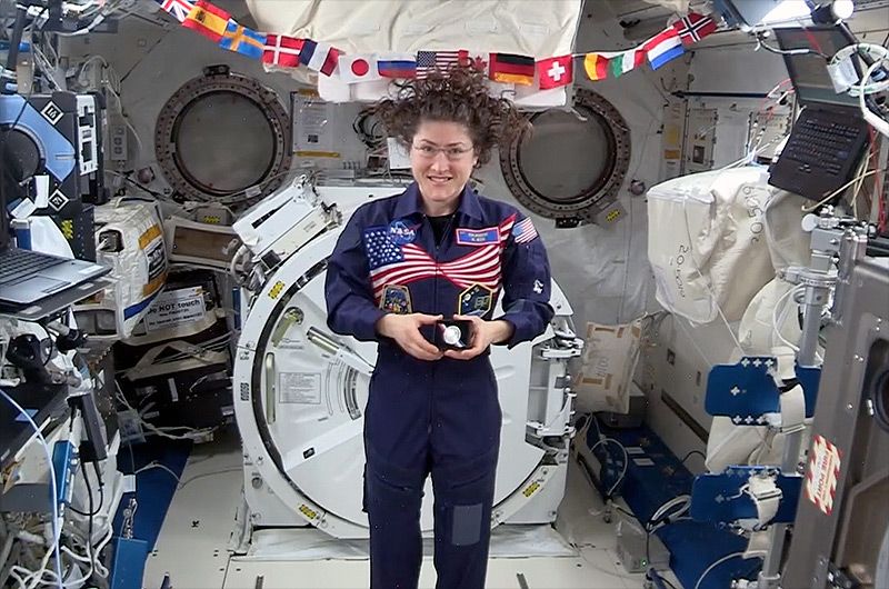 NASA astronaut Christina Koch displays a U.S. Mint Apollo 11 50th Anniversary commemorative coin on board the International Space Station in May 2019.