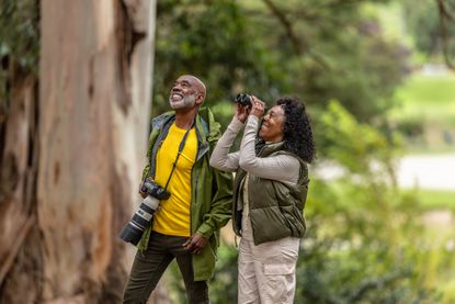 African American couple on a outdoor walk and hike enjoying bird watching and photography.