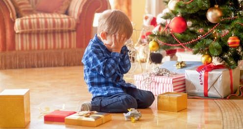 Boy crying at Christmas tree