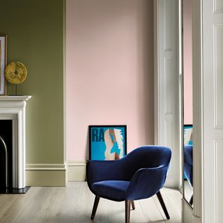 skirting board colour ideas, pink and green living room with electric blue armchair, pale green skirting boards, artwork, pale wood flooring