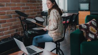 Woman with a laptop on an electronic drum kit