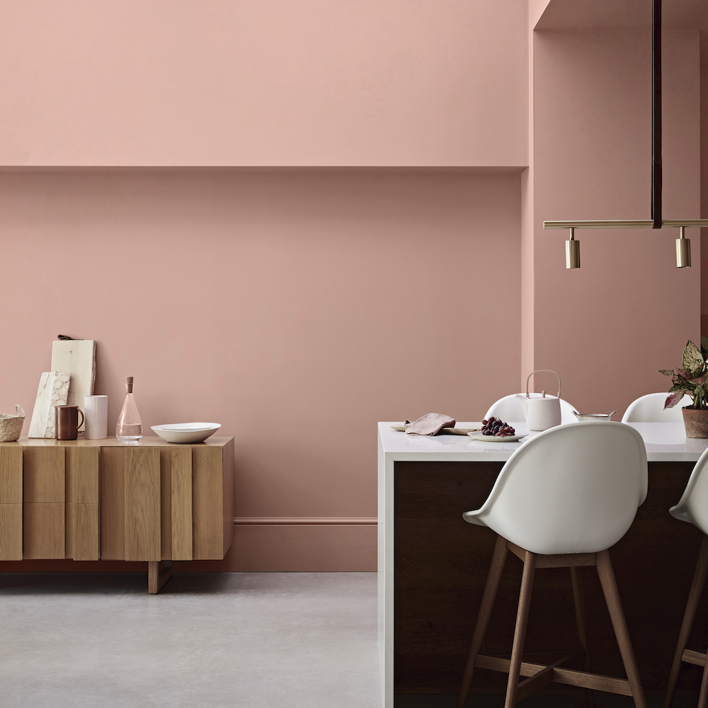 room with white chair pink wall and white table