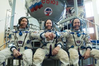 Expedition 55 crew members Drew Feustel of NASA (left), Oleg Artemyev of Roscosmos (center) and Ricky Arnold of NASA (right) pose for a crew portrait at the Gagarin Cosmonaut Training Center in Star City, Russia on Feb. 21, 2018. The crew launched to the International Space Station on a Soyuz rocket March 21.