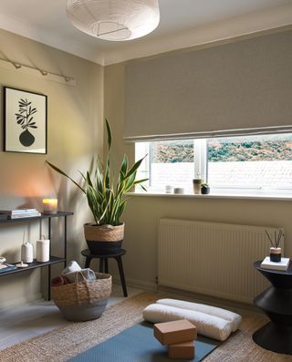 A home yoga studio with a jute rug and natural roman blind in the window
