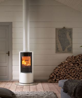 A white curved log burner in a modern log cabin