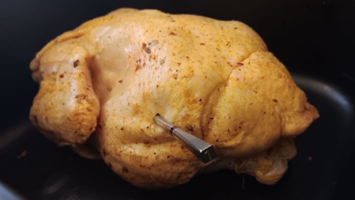 Uncooked chicken coated in spices and ready to cook with Meater Pro XL probe