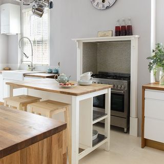 light grey walls with a wooden island and wooden stools