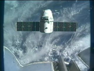 SpaceX's Dragon space capsule hovers just below the International Space Station's robotic arm in this view from an arm camera on Oct. 10, 2012, during the CRS-1 commercial cargo mission.