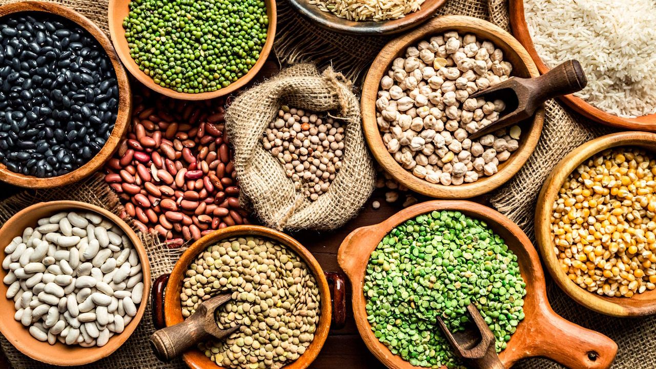 A selection of lentil beans in pots on a table