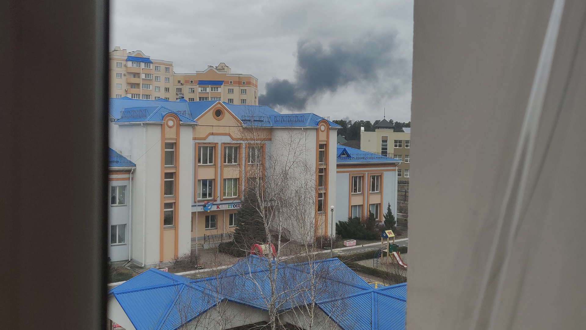Photo à travers la fenêtre de Nikita surplombant le bombardement de l'aéroport de Hostomel.