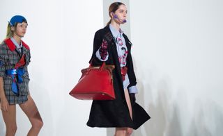 Model is carrying red color bag.