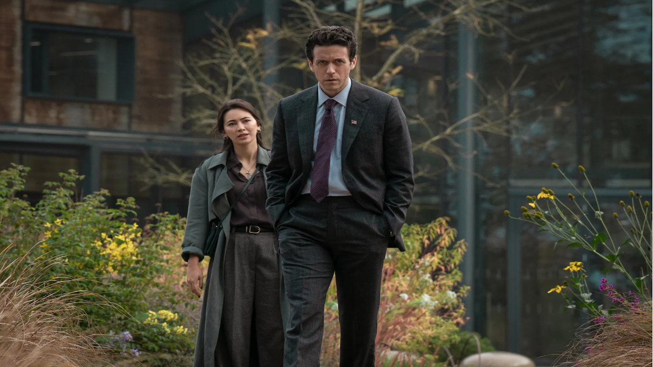a man and woman walking together amid overgrown shrubbery