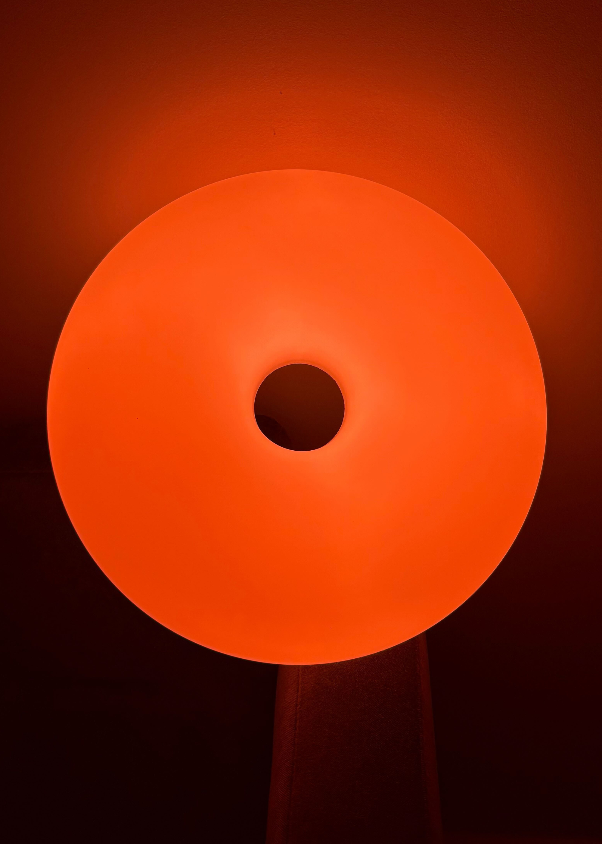 The IKEA VARMBLIXT donut lamp reflecting orange light