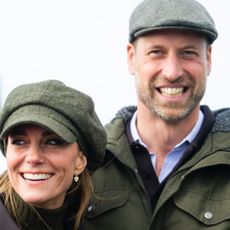 Princess Kate and Prince William smiling and wearing flat caps