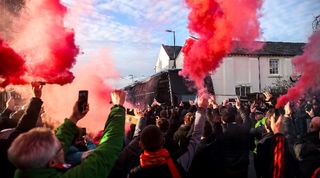 Liverpool fans let off flares and smoke bombs as the team buses arrive ahead of the Reds' Premier League game against Manchester United at Anfield in December 2023.