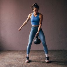 20 minute kettlebell workouts: A woman working out with a kettlebell at home