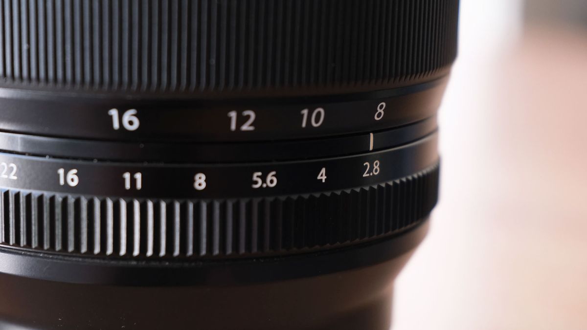 A close-up of the Fujifilm XF 8-16mm f/2.8 lens showing the widest aperture of f/2.8