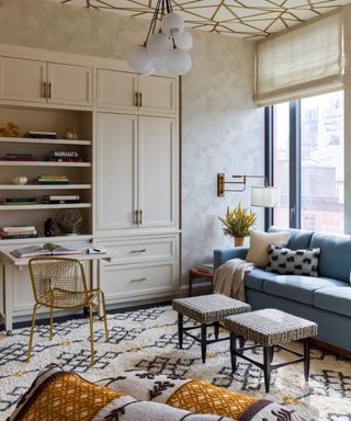 guest room office with built in storage and desk with a blue sleeper sofa