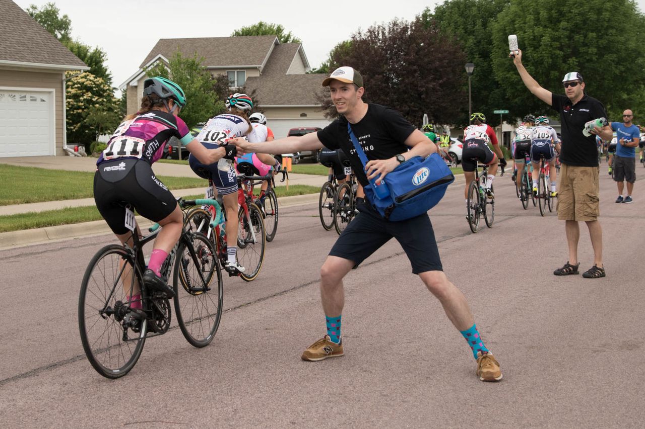 Kevin Pietka (Chicago, IL) hands water to Carrie Cartmill (Rise Racing) in the feed zone mid-race.