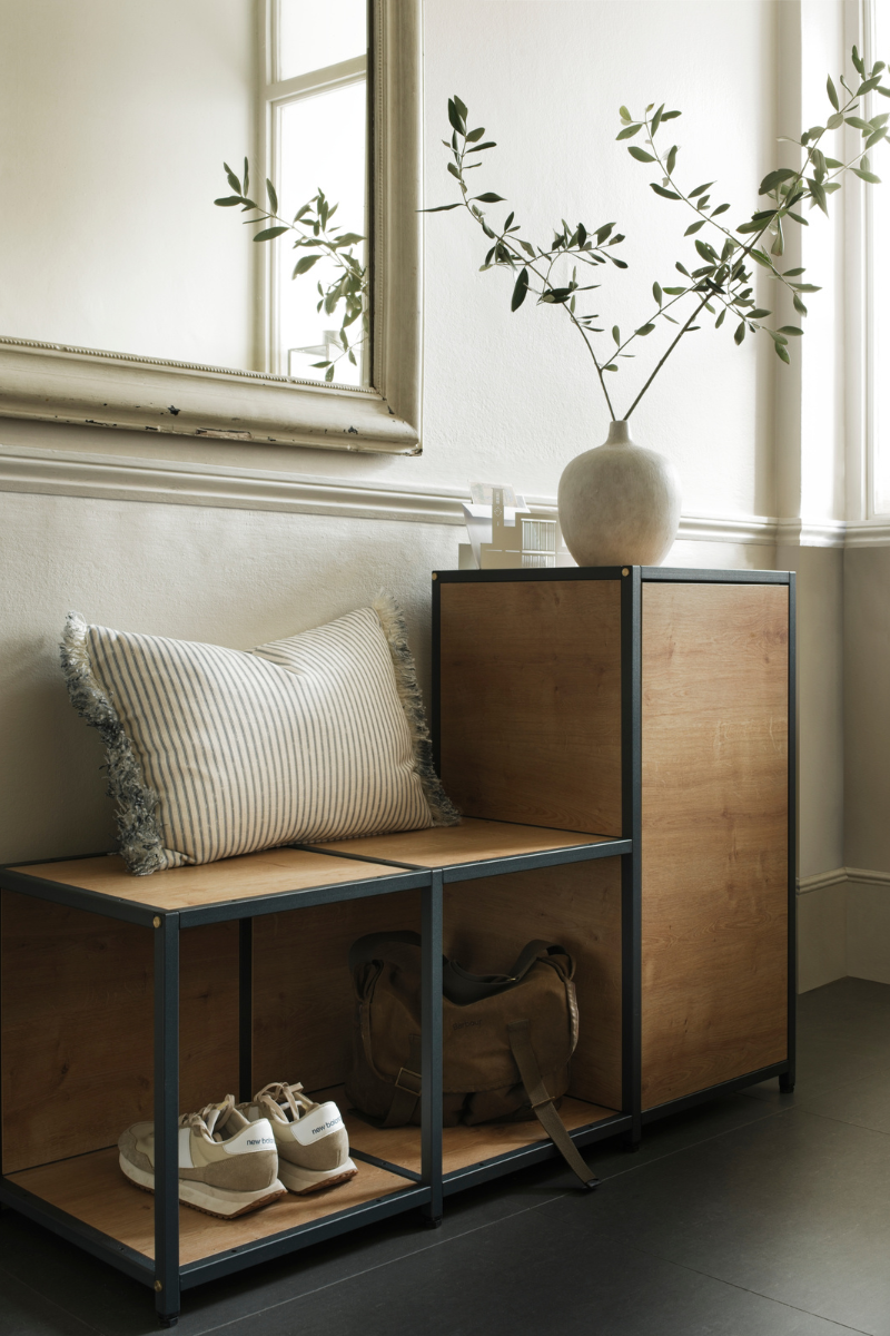 hallway storage unit styled with cushion and vase