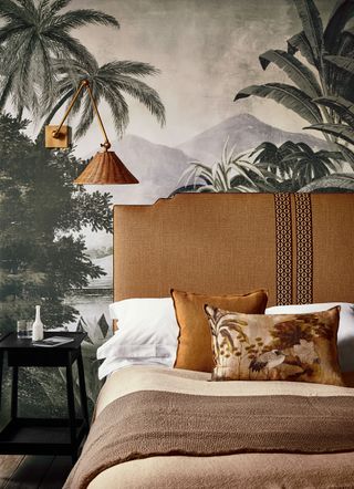An example of headboard ideas showing a vintage-style bed with an orange headboard in front of a jungle wall mural