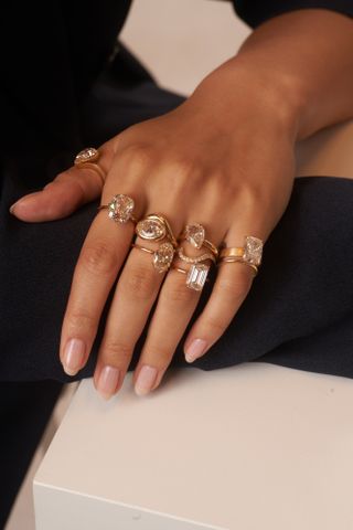 Hand wearing different champagne colored diamond rings from Aaryah.