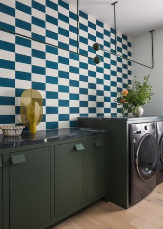 a laundry room with checkerbord wallpaper and custom hanging storage