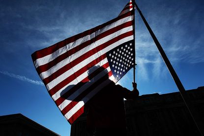 An Occupy DC protester holds an American flag upside down